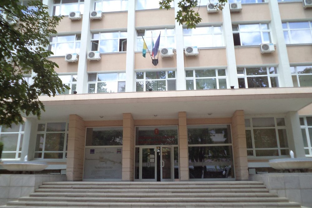 Административна сграда с флагове пред главния вход